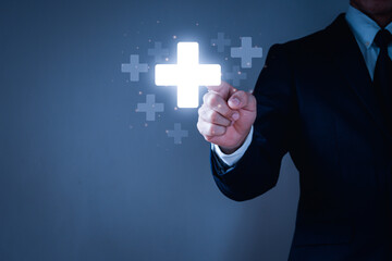 Businessman waer a suit ,his hand touching plus sign icon means to offer positive thing.Concept is...