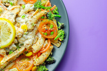 Piri piri style chicken on a bed of wholewheat pasta and vegetables, with a cool sour cream and chive dressing