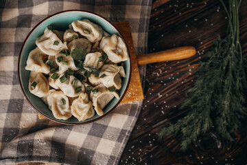 Boiled dumplings in a deep bowl, sprinkled with fresh green onions