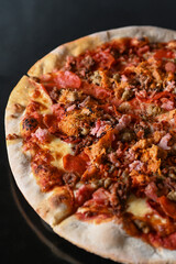 Meat lovers pizza on black background