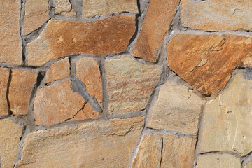 Fragment of a wall from a chipped stone, stone wall texture. decorative stone, different colors.