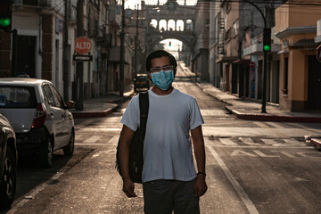 Fototapeta na wymiar Portrait of a boy walking in empty streets of a city with a medical mask.