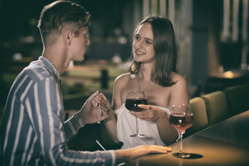 Romantic couple sitting at bar drinking wine