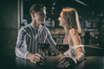 Couple drinking red wine during evening time at bar