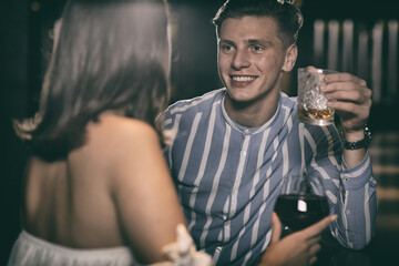 Cheerful couple sitting at bar counter and chatting