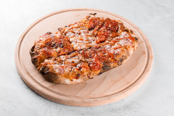 Pinsa romana gourmet italian cuisine on white background. Scrocchiarella. Pinsa with pepperoni, tomatoes, cheese.