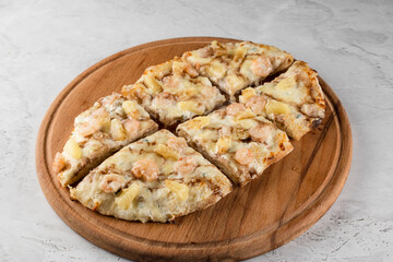 Pinsa romana with shrimps and pineapple on wooden plate on white background. Seafood scrocchiarella.