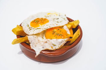 racion de patatas fritas con huevos fritos en un bar de tapas
