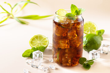 Cuba Libre alcoholic drink, Cola with ice cubes or lemonade on a pastel brown background.