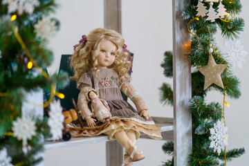 Fototapeta na wymiar interior doll with human face, made by hand from textiles, in a retro style, sits on a shelf against the background garland of lights. creating dolls for the holiday. an exclusive gift. Companion Doll