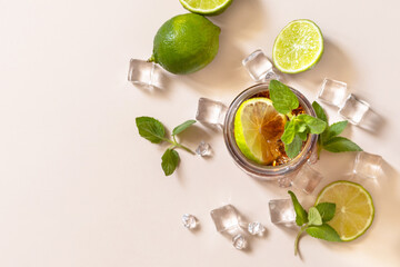 Cuba Libre alcoholic drink, Cola with ice cubes or lemonade on a pastel brown background. Top view...