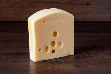 Hard cream cheese on a dark wooden background. Delicious and healthy food