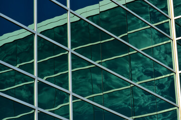 Multi story office building with it"s many windows creates reflections of the building  creating interesting angles and lines.