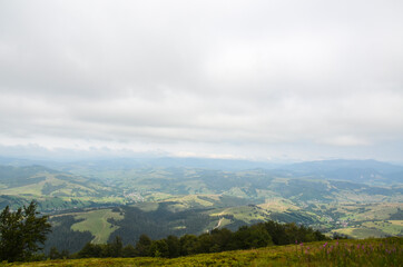 Houses between mountains of village Izky with residential and under construction resort cottages in foggy valley Carpathians, Ukraine