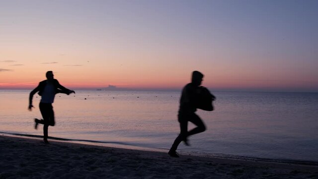 A man runs after a bag thief along the seashore in the early morning. Cases of theft on vacation. Super slow motion video.