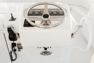 Internal control cabin of a motor yacht. Control panel, steering wheel and gear levers.
