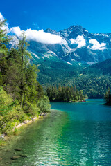 Fototapeta na wymiar Faboulus landscape of Eibsee Lake with turquoise water in front of Zugspitze summit under sunlight. Location: Eibsee lake, Garmisch-Partenkirchen Bavarian alps, Germany, Europe
