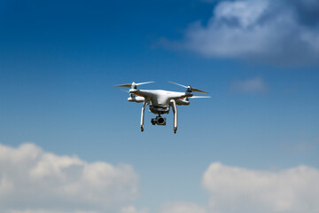 drone on a background of blue sky with clouds. quadcopter in flight. sunny day.