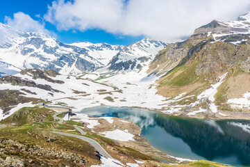 Naklejka na ściany i meble Beautiful emerald Alpine Lake in the snowy landscape in Gran Paradiso National Park Italy