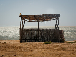 Fototapeta premium Background of the Sea at Bahia Honda Beach with a Ecological Little Store Made from Dried Banana Leaves and Logs in La Guajira, Colombia