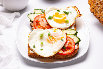 Sandwiches with egg, tomatoes, cucumber on toasted bread. Close up.