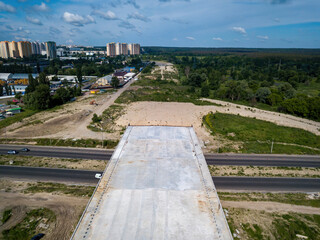An unfinished bridge across the road. Aerial drone view.