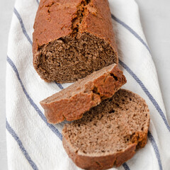 Whole grain rye bread in slices on white kitchen towel
