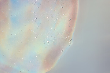 Background from cosmetic gel with bubbles on the holographuc texture.Copy space for text or design.Top view,antibacterial liquid surface.Good as background or cosmetics mockup.