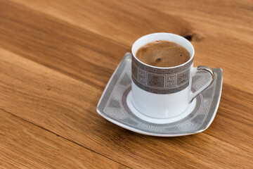A cup of Traditional Turkish Coffee with wooden background.