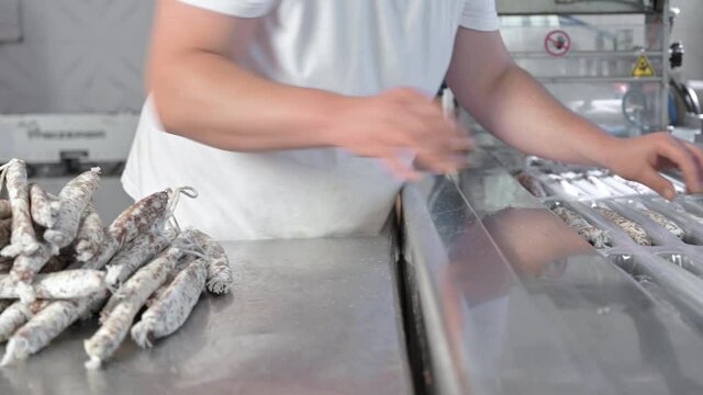 Sausages. Packing line of sausages Fuet is a Catalan thin, cured, dry sausage of pork meat in a pork gut . Industrial manufacture of sausage products. High quality 4k footage