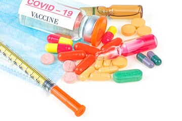 Syringe with glass vials and medicinal tablets and pills isolated on a white background. Covid-19 vaccine. Assorted medical drugs.