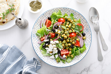 Mediterranean Greek and chickpea salad with fresh vegetables and feta cheese, top view