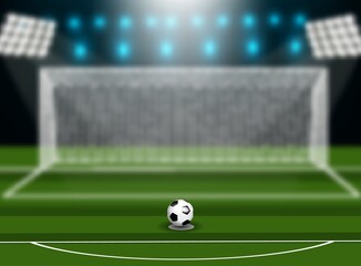 Soccer ball on green field in front of goal post.