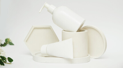 Podium of geometric shapes with cosmetic product on white background
