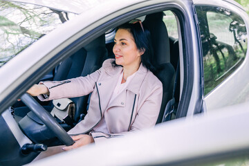 lifestyle and people concept - happy smiling young woman driver driving a car.