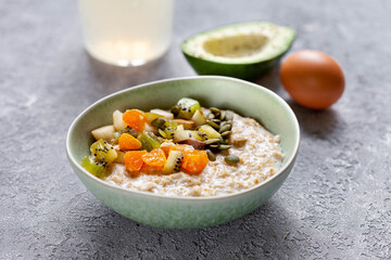 Oatmeal with fruits, nuts, seeds and honey, healthy breakfast concept