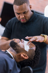 applying cleansing cream in latin hairdresser to proceed to the haircut. rings and watch in the hands of the barber.hairdresser carefully applying flat half body..