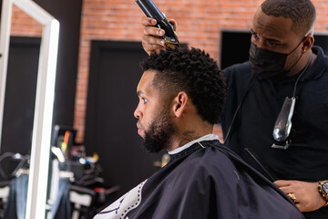barber cutting hair for young people. in barber shop for all ages and styles.
