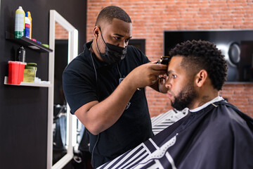 hairdresser cutting hair to young man. in barber shop for all ages and styles. shaping hair cut .