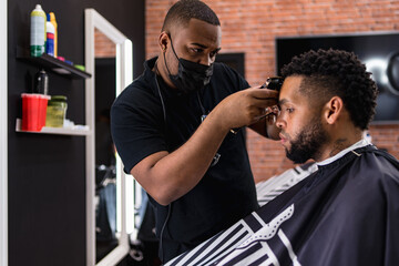 hairdresser cutting hair to young man. in barber shop for all ages and styles. shaping hair cut .