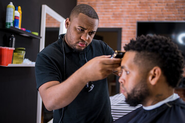 hairdresser cutting hair to young man. in barber shop for all ages and styles. shaping hair cut .