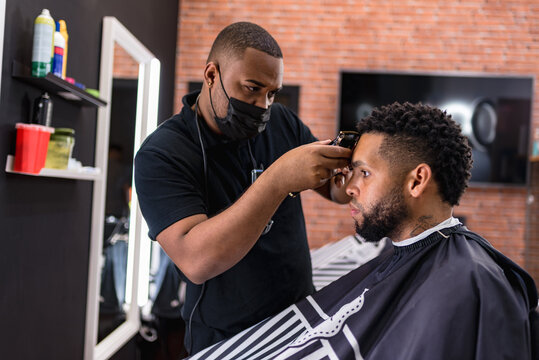 hairdresser cutting hair to young man. in barber shop for all ages and styles. shaping hair cut .