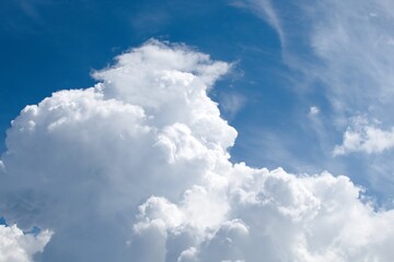 Naklejka na ściany i meble Large white cloud against blue sky. Small birds on white cloud background