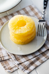 Canned sliced pineapple fruit on plate.