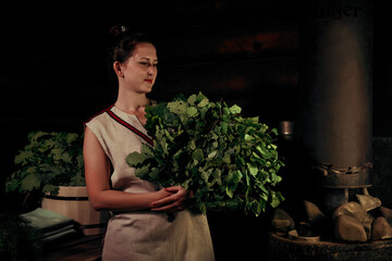 woman with bath brooms in a traditional steam sauna banya