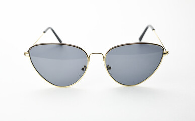 Fashionable sunglasses in thin gold frames on a white background. 