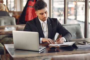 Stylish businessman working in a cafe and use the laptop