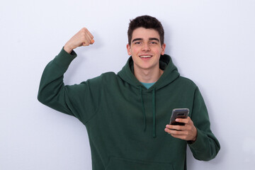 happy teenage student isolated with cell phone euphoric with success