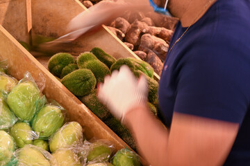 Worker re-stocks fresh spine chayote at the local farmers market