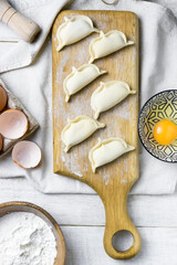 Cooked dumplings on a plate on a light table with ingredients 